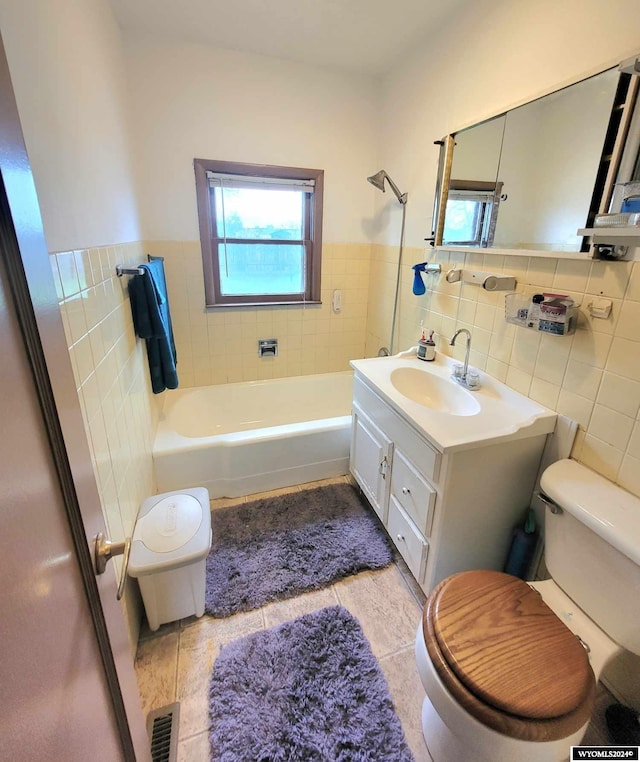 full bathroom with tile patterned floors, vanity, toilet, and tile walls