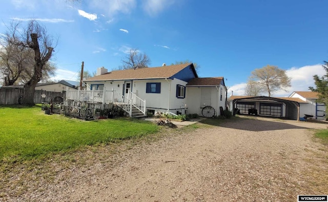 view of front facade featuring an outbuilding, a front yard, and a garage