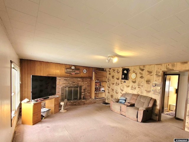 living room featuring light carpet, a fireplace, and wooden walls