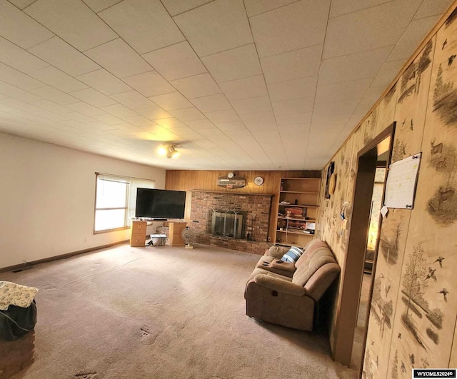 living room featuring carpet, wooden walls, and a brick fireplace