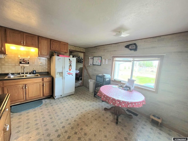 kitchen with white refrigerator with ice dispenser and sink