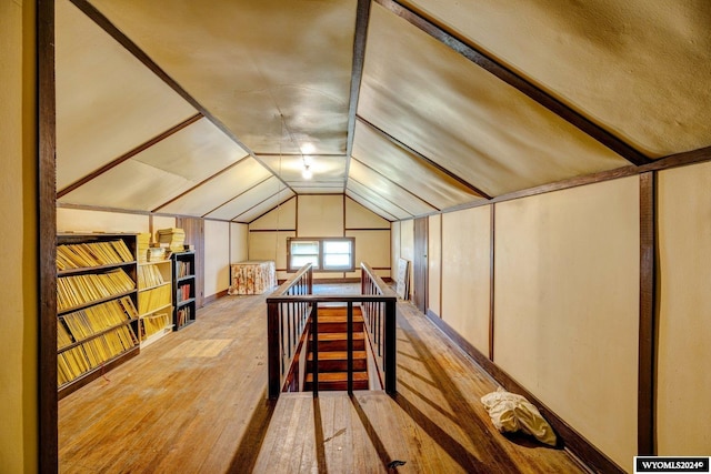 additional living space featuring vaulted ceiling and hardwood / wood-style flooring