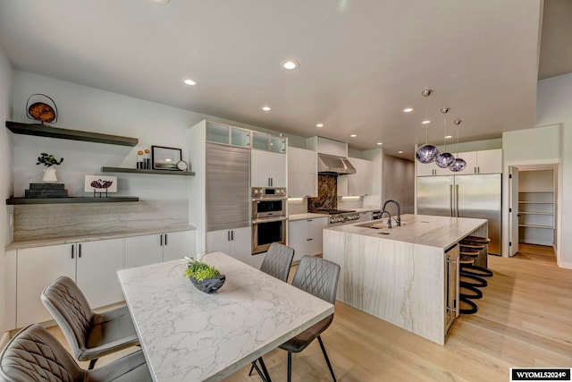 dining room featuring beverage cooler, sink, and light hardwood / wood-style floors