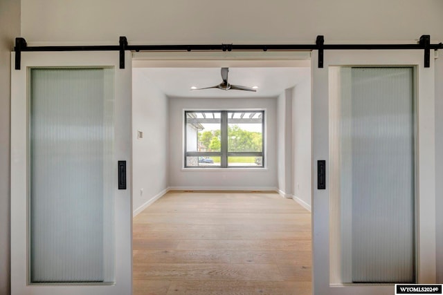 interior space with a barn door and light hardwood / wood-style floors