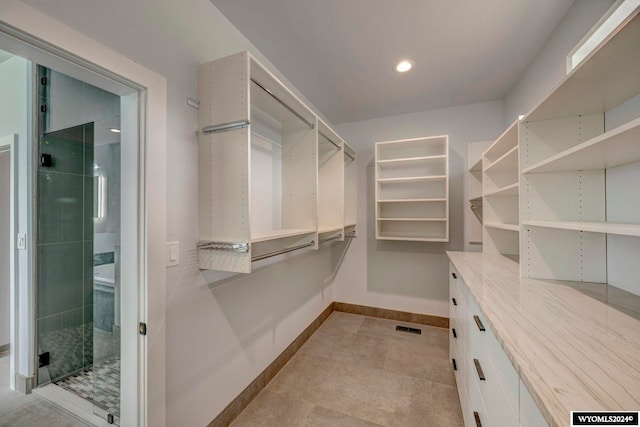 walk in closet featuring light tile floors