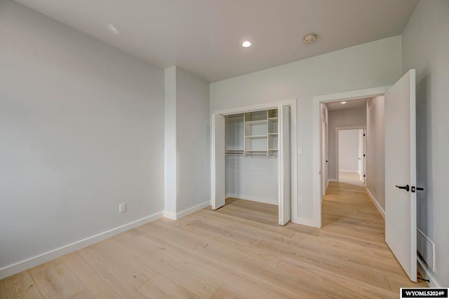 unfurnished bedroom with light hardwood / wood-style floors and a closet