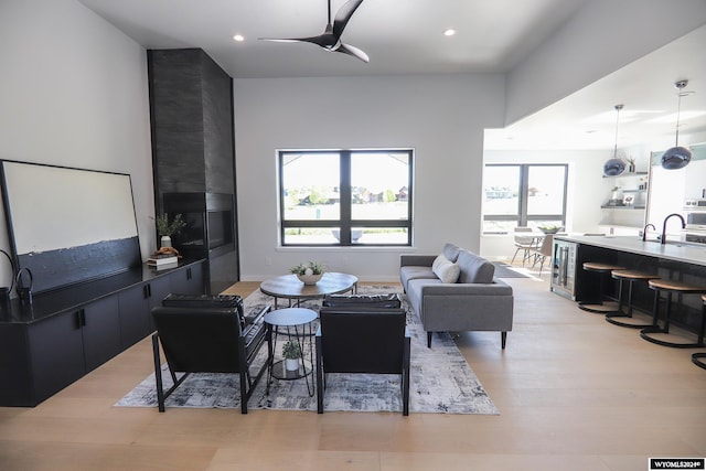 living room with light wood-type flooring and ceiling fan