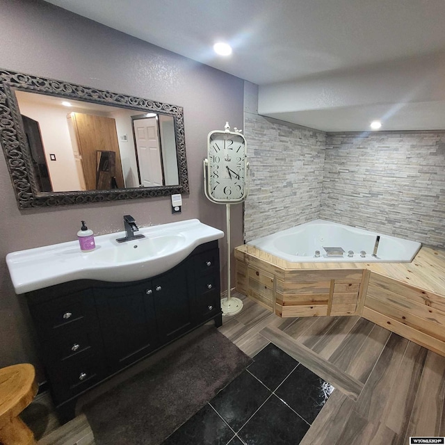 bathroom featuring a bath, wood-type flooring, and vanity