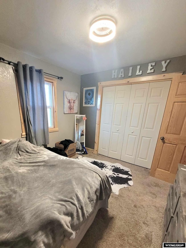 bedroom with carpet, a textured ceiling, and a closet