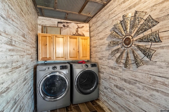 laundry area featuring dark hardwood / wood-style flooring, washer and dryer, wooden walls, and cabinets