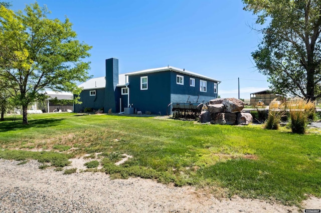 exterior space featuring a lawn and central AC unit