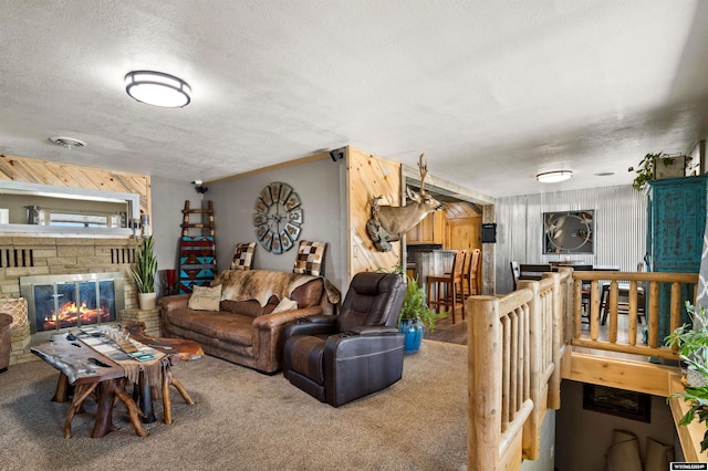 carpeted living room featuring wood walls, a fireplace, and a textured ceiling