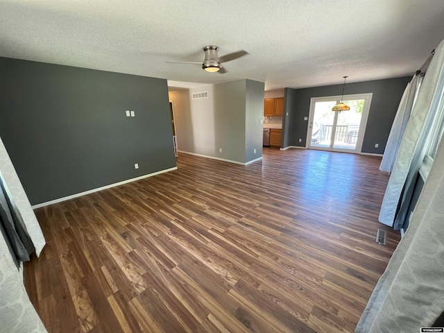 unfurnished living room with a textured ceiling, ceiling fan, and dark hardwood / wood-style floors