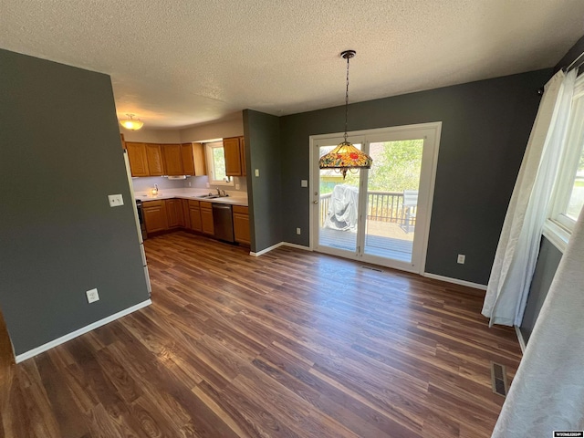 kitchen with a textured ceiling, dishwasher, dark hardwood / wood-style floors, and hanging light fixtures