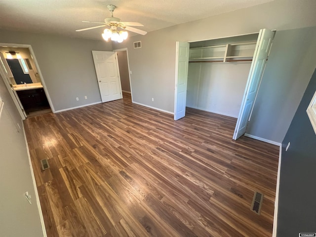 unfurnished bedroom with dark hardwood / wood-style floors, ceiling fan, connected bathroom, and a closet