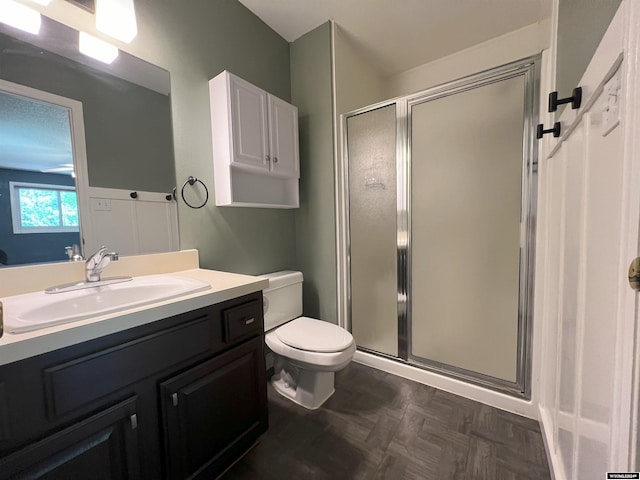 bathroom featuring vanity, toilet, an enclosed shower, and parquet floors