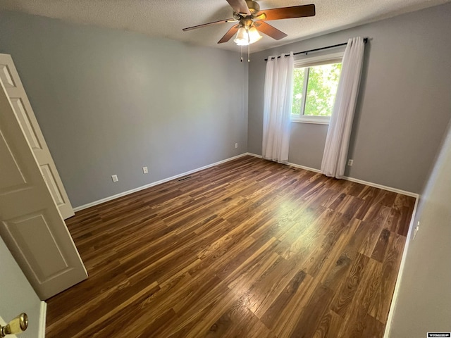 unfurnished room featuring ceiling fan, dark hardwood / wood-style flooring, and a textured ceiling