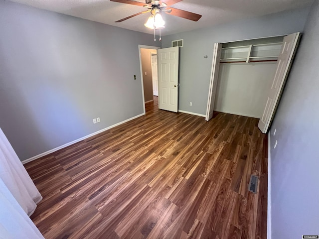 unfurnished bedroom featuring ceiling fan, dark hardwood / wood-style flooring, a textured ceiling, and a closet