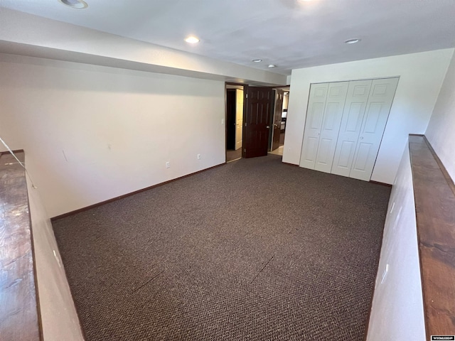 interior space with dark carpet and a closet