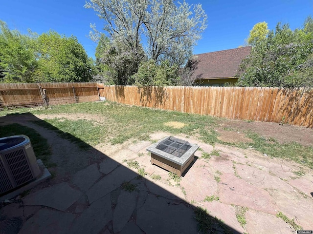 view of yard featuring central AC unit and an outdoor fire pit