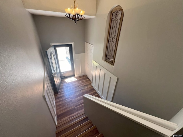 stairway featuring a chandelier and wood-type flooring