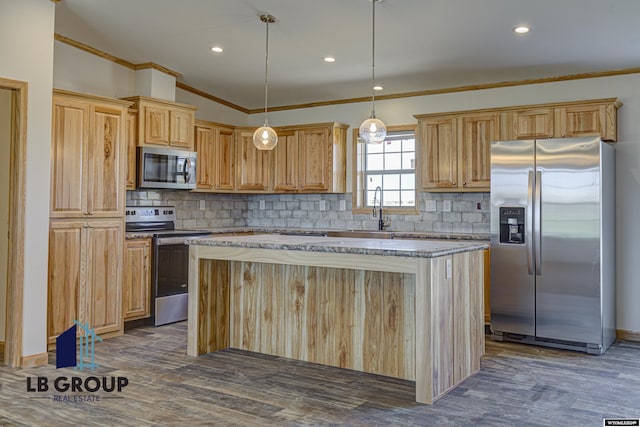 kitchen featuring dark wood-type flooring, ornamental molding, appliances with stainless steel finishes, a kitchen island, and pendant lighting