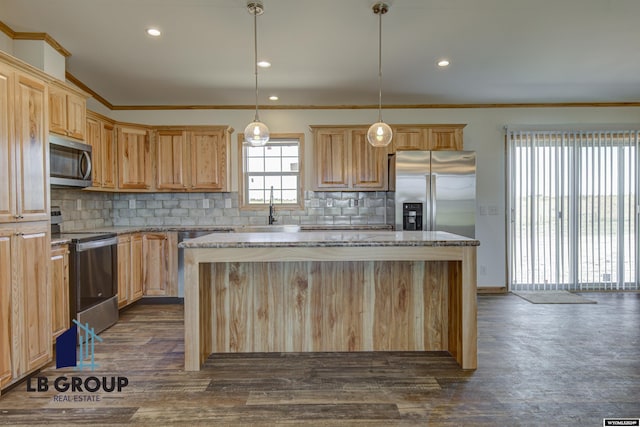 kitchen featuring stainless steel appliances, ornamental molding, hanging light fixtures, and a center island