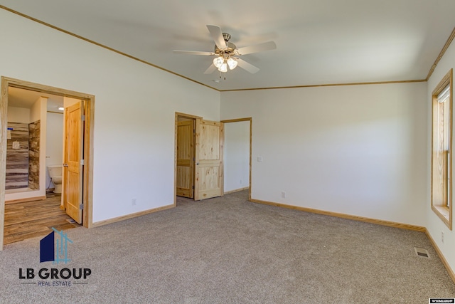 unfurnished bedroom featuring ceiling fan, light colored carpet, ornamental molding, and connected bathroom