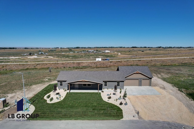 view of front of home featuring a garage, a rural view, and a front yard