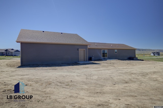 back of house with central air condition unit