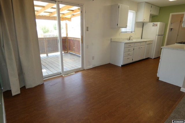 kitchen featuring white cabinetry, white appliances, dark hardwood / wood-style flooring, and sink