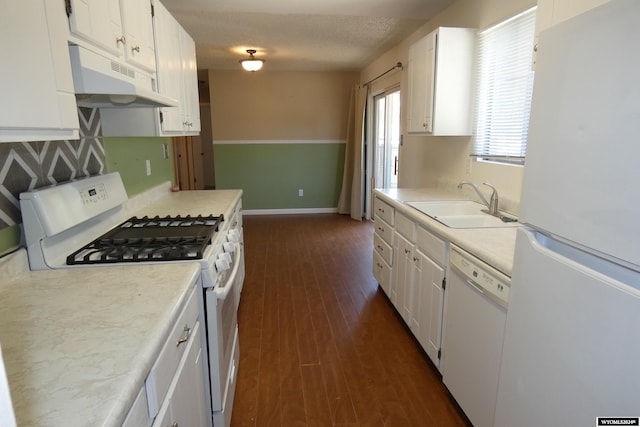 kitchen featuring sink, white appliances, a wealth of natural light, and white cabinets