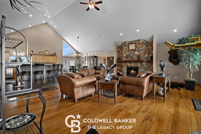 living room featuring a fireplace, plenty of natural light, high vaulted ceiling, and light wood-type flooring