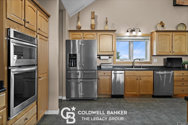 kitchen featuring lofted ceiling, stainless steel appliances, dark tile patterned flooring, and sink