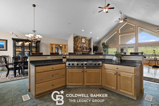 kitchen with an island with sink, stainless steel gas cooktop, pendant lighting, and a notable chandelier