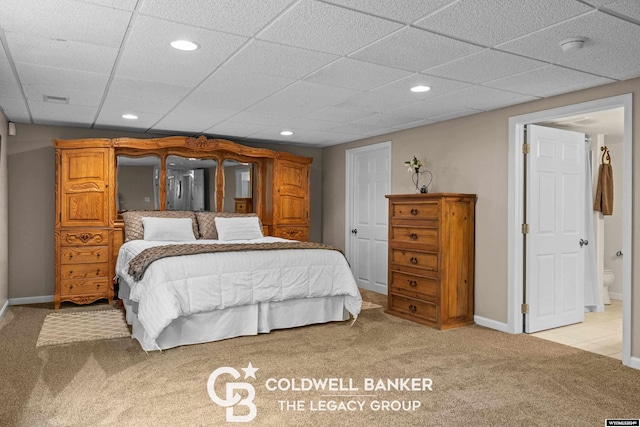 carpeted bedroom featuring a drop ceiling