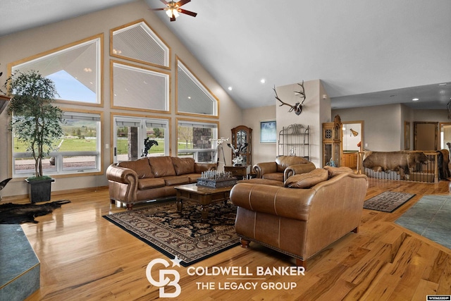 living room featuring high vaulted ceiling and light wood-type flooring