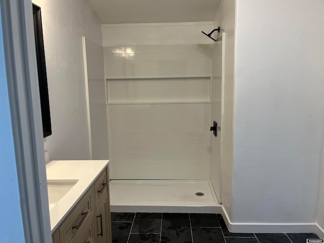 bathroom featuring vanity, tile patterned flooring, and tiled shower