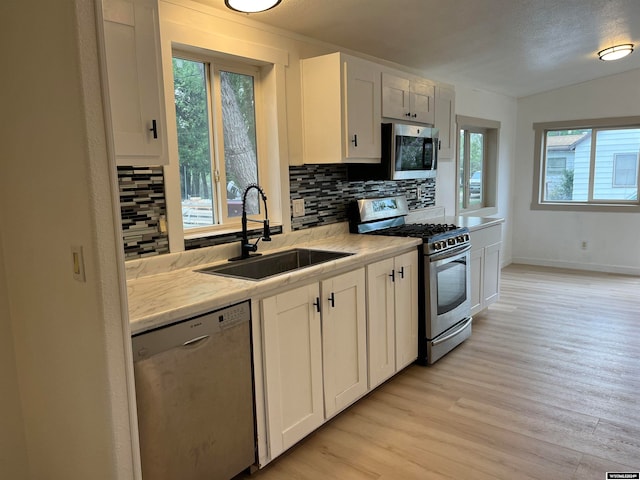 kitchen featuring white cabinetry, sink, light hardwood / wood-style flooring, and stainless steel appliances