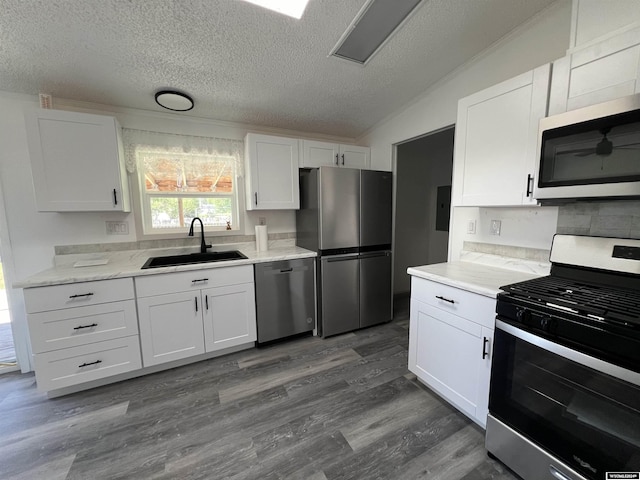 kitchen with stainless steel appliances, white cabinetry, and sink