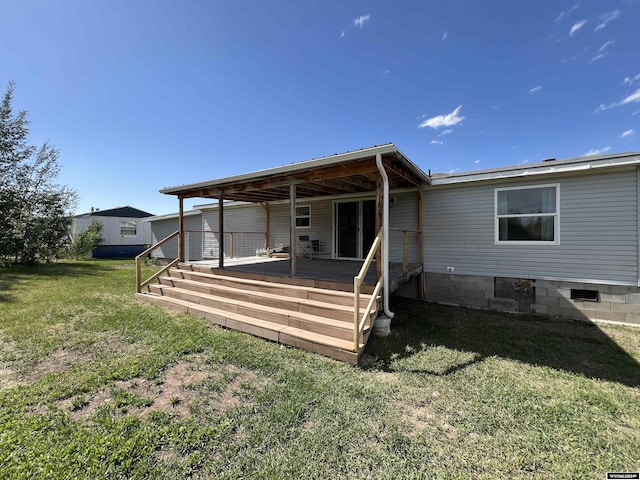 rear view of house with a yard and a deck