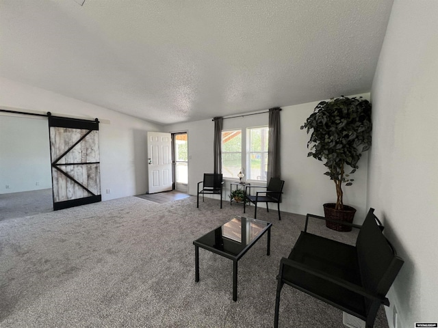 living room featuring a barn door, lofted ceiling, a textured ceiling, and carpet floors