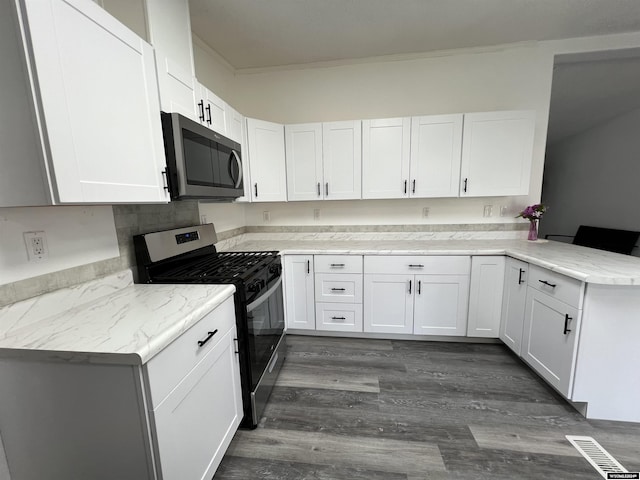 kitchen featuring kitchen peninsula, appliances with stainless steel finishes, and white cabinetry