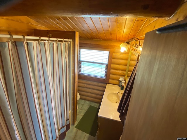 bathroom featuring rustic walls, vanity, toilet, and wood ceiling