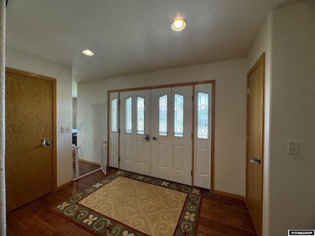 foyer with a textured ceiling and dark hardwood / wood-style floors