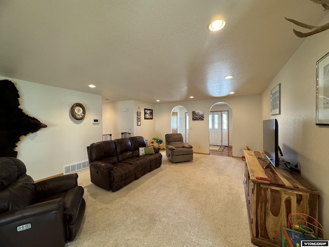 carpeted living room featuring a textured ceiling