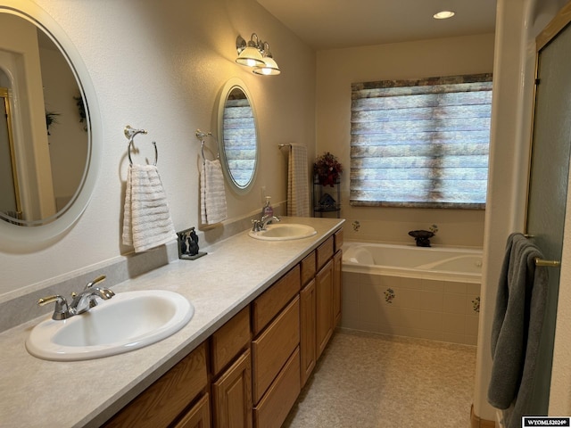 bathroom featuring tiled bath and vanity