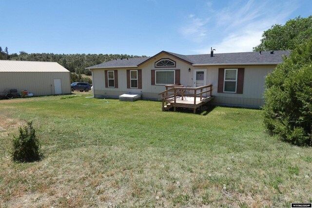 back of house with a deck and a yard