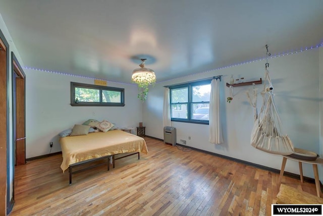 bedroom with hardwood / wood-style flooring and a notable chandelier