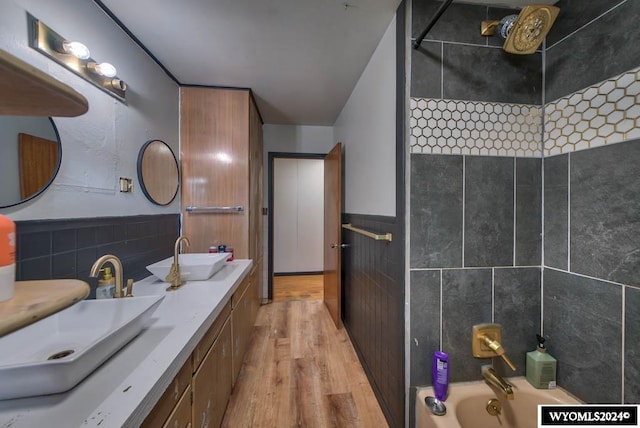 bathroom with tile walls, shower / bathing tub combination, vanity, and hardwood / wood-style flooring